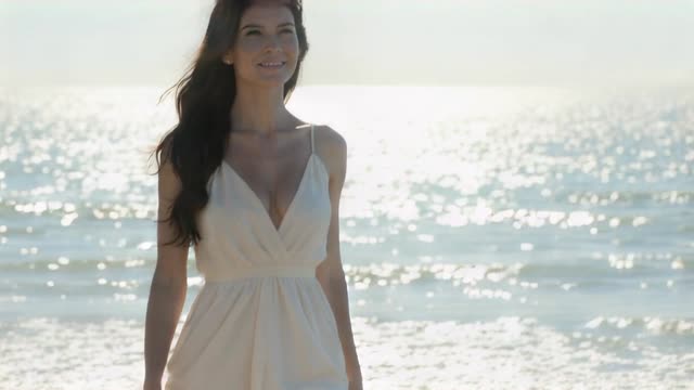 A bride walking along a bright shoreline