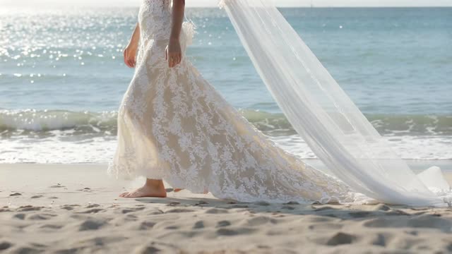 A bride walking at the edge of the sea